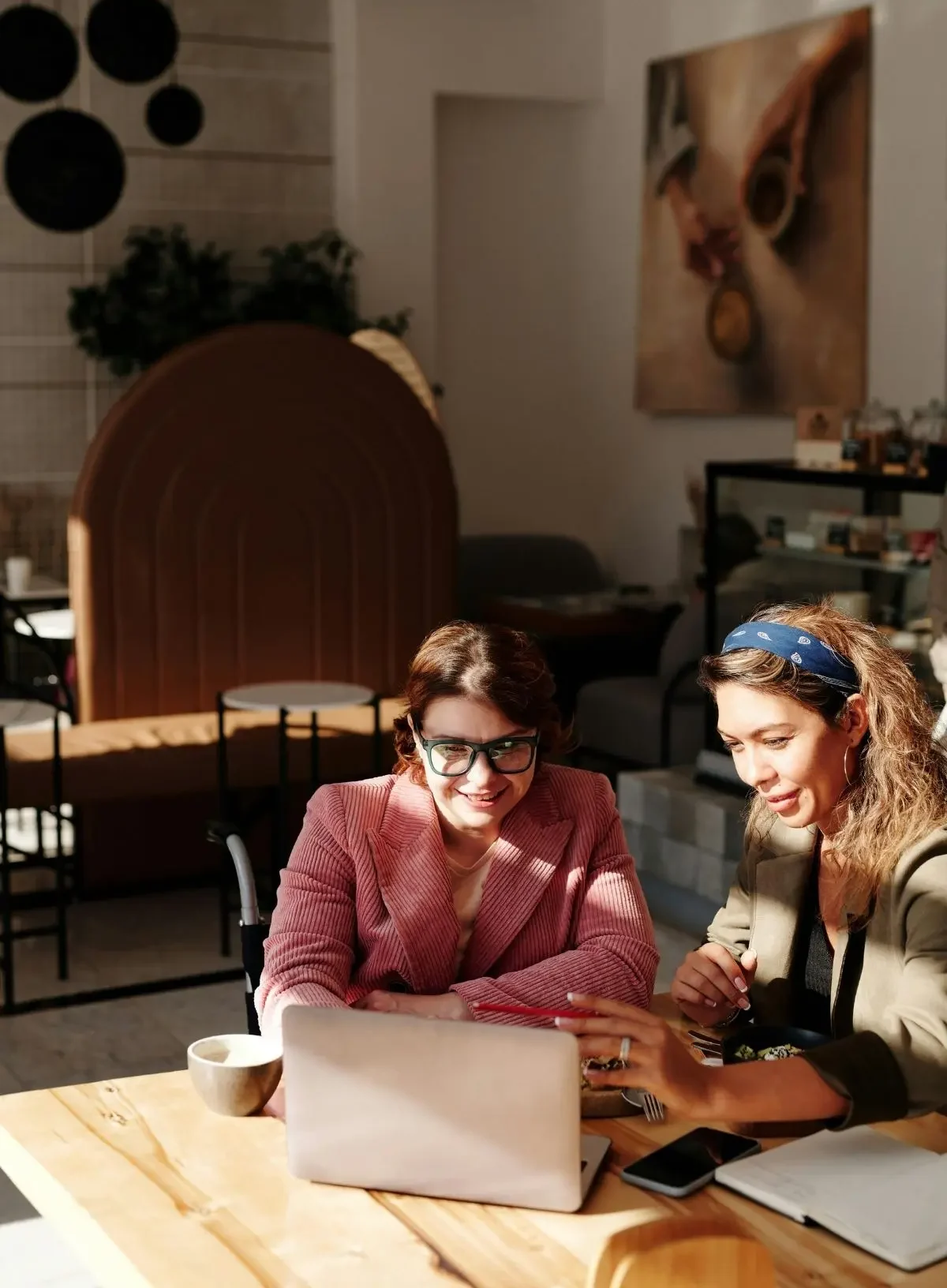 A coffee shop with two business owners working on a laptop together