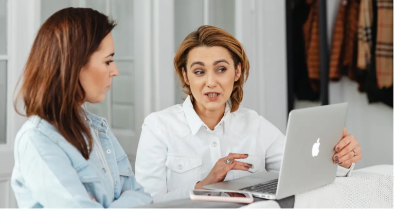 A female entrepreneur looking at a gray laptop with her business coach